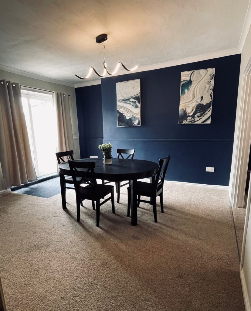 Beige Dining room with blue feature wall and black dining table