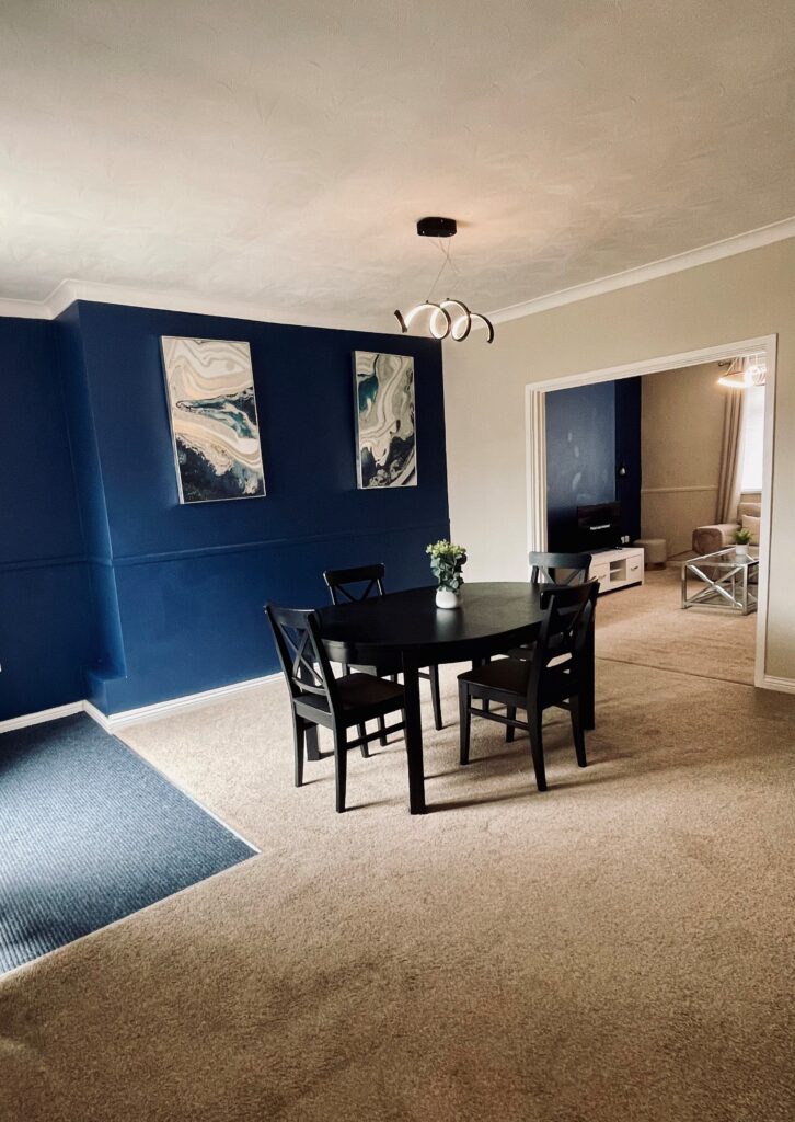 Beige Dining room with blue feature wall and black dining table