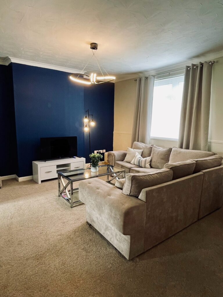 Beige living room with blue feature wall and black coffee table