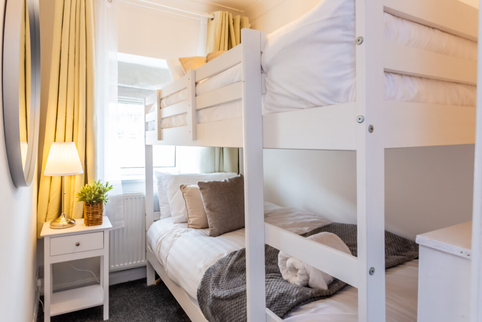 White bunk bed bedroom with grey and beige accessories