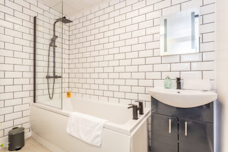 White shower bathroom with black accessories