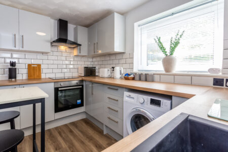 White u shaped kitchen with oak worktops