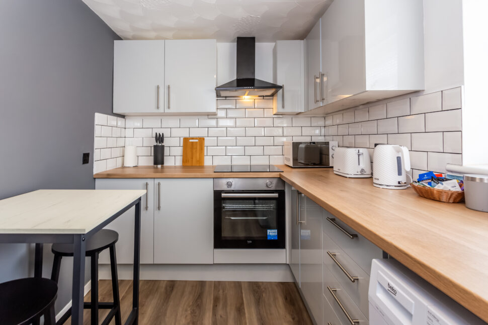 White u shaped kitchen with oak worktops