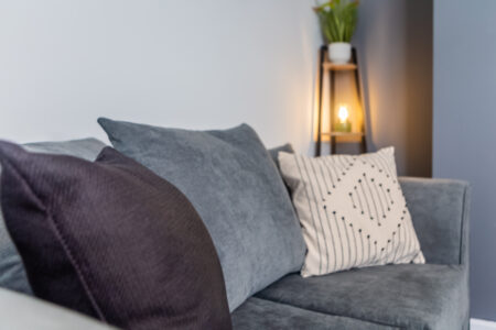 Off white living room with grey feature wall. Black coffee table. Grey curtains