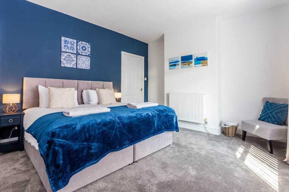 Navy king bedroom with grey accessories