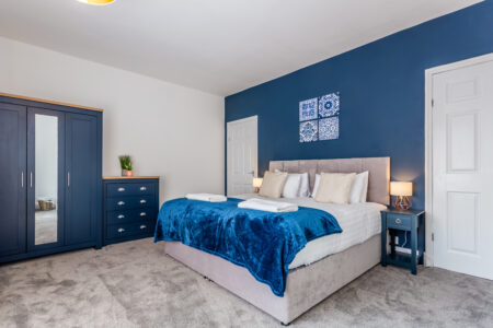 Navy king bedroom with grey accessories