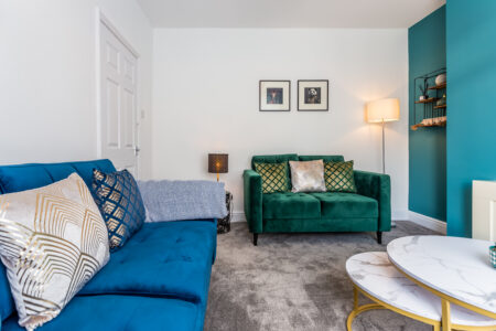 Green and blue living room. Fireplace feature wall. Gold accessories