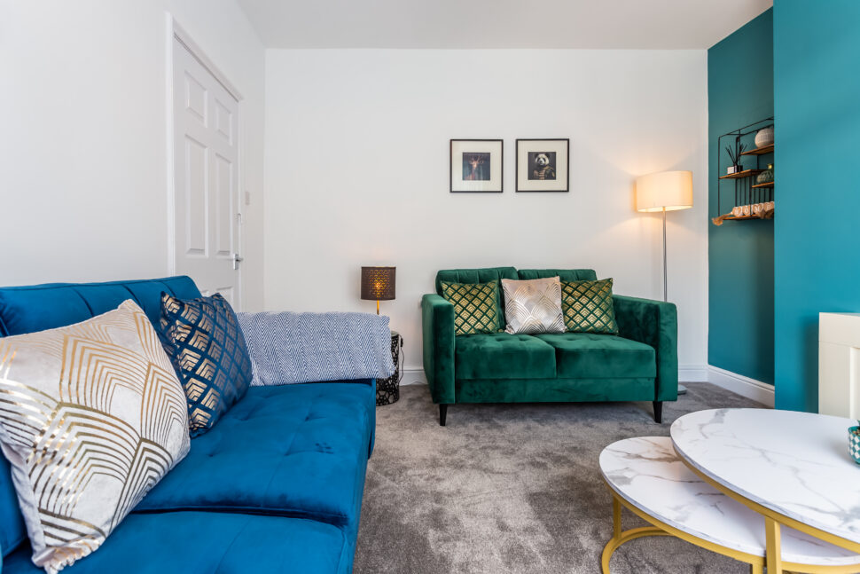 Green and blue living room. Fireplace feature wall. Gold accessories