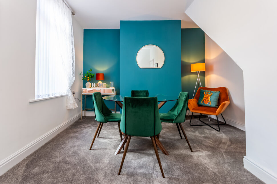 Green and blue dining room with orange accessories