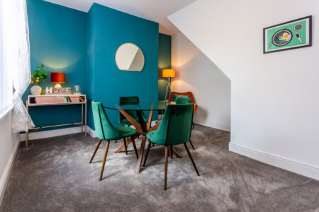 Green and blue dining room with orange accessories