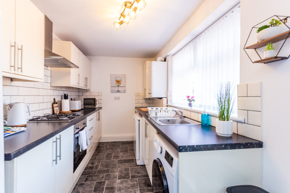 White galley kitchen with black worktops