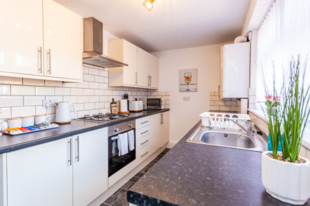 White galley kitchen with black worktops