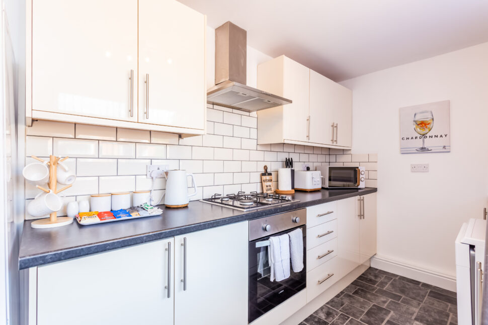 White galley kitchen with black worktops