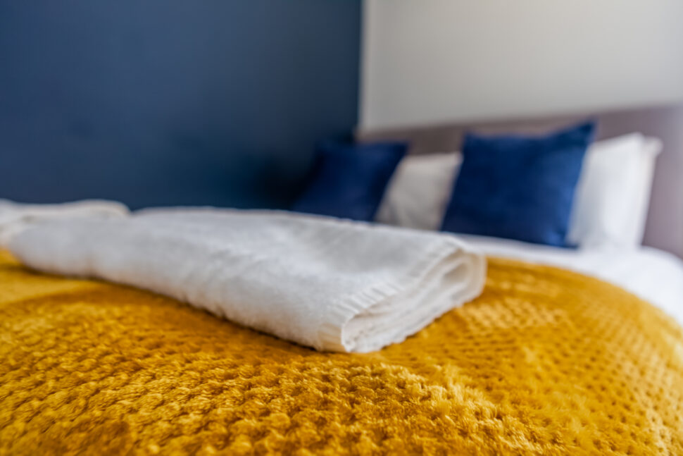 Navy double bedroom with yellow accessories