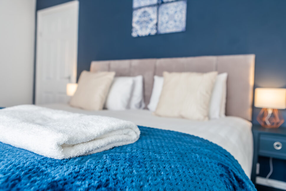 Navy king bedroom with grey accessories