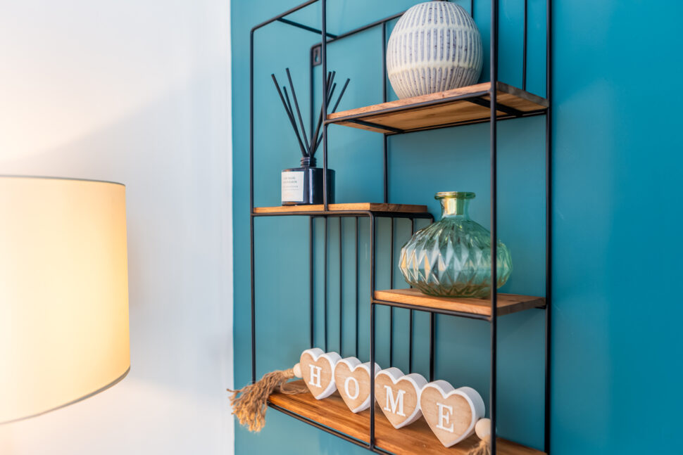 Green and blue living room. Fireplace feature wall. Gold accessories