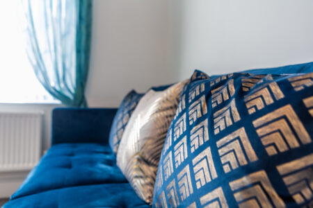 Green and blue living room. Fireplace feature wall. Gold accessories