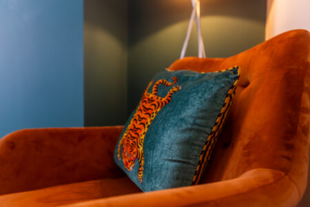 Green and blue dining room with orange accessories