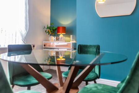 Green and blue dining room with orange accessories