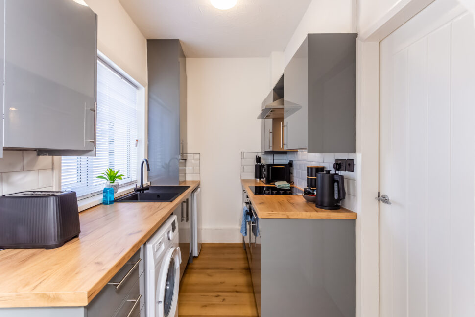 Off white galley kitchen. Grey kitchen with oak worktops