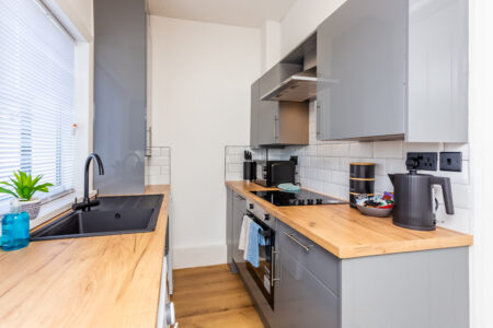 Off white galley kitchen. Grey kitchen with oak worktops