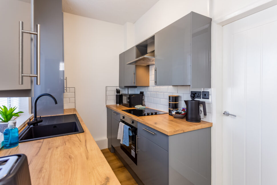 Off white galley kitchen. Grey kitchen with oak worktops