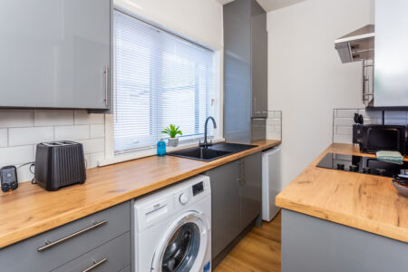 Off white galley kitchen. Grey kitchen with oak worktops