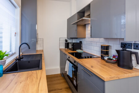 Off white galley kitchen. Grey kitchen with oak worktops