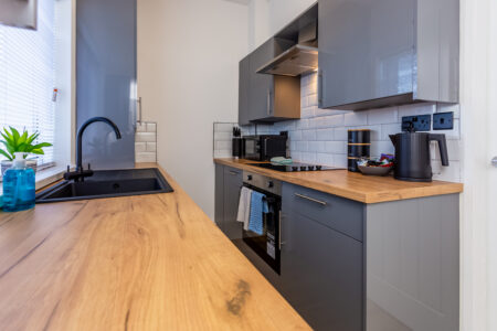 Off white galley kitchen. Grey kitchen with oak worktops