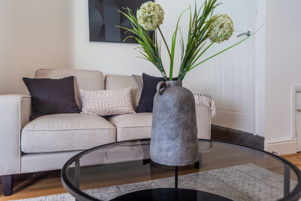 Off white living room. Beige Sofas. Black circular coffee table