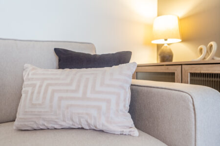 Off white living room. Grey feature wall. Beige Sofas.