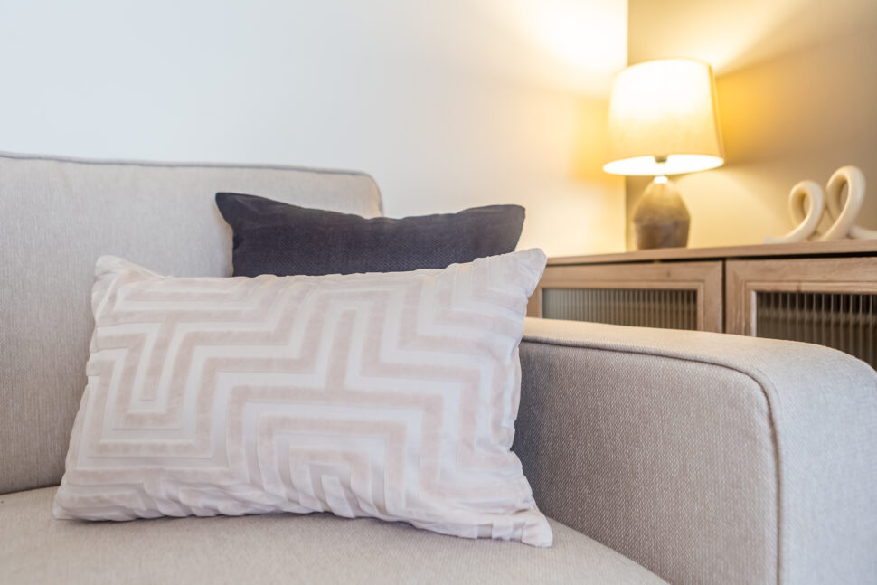 Off white living room. Grey feature wall. Beige Sofas.