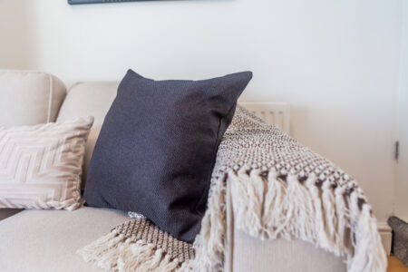 Off white living room. Grey feature wall. Beige Sofas.