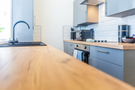 Off white galley kitchen. Grey kitchen with oak worktops