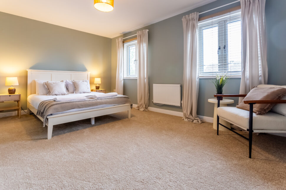 Light blue bedroom. Off-white king bed. Oak bedside tables