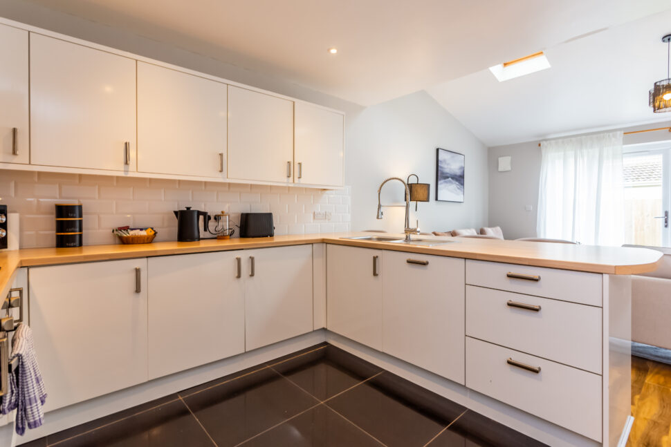 White kitchen with peninsular island with oak worktops