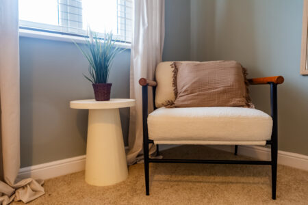 Light blue bedroom. White boucle accent chair. White pedestal side table