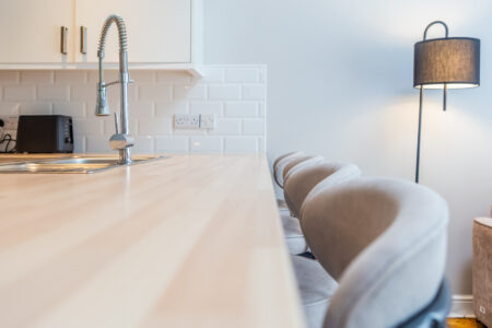 White kitchen with peninsular island with oak worktops