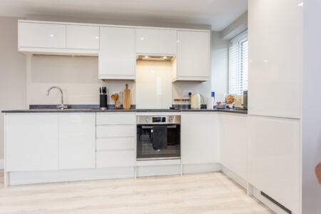 Toast Stays, showing clean, modern, white high-gloss kitchen units