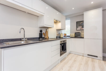 Toast Stays, showing clean, white, high-gloss kitchen units