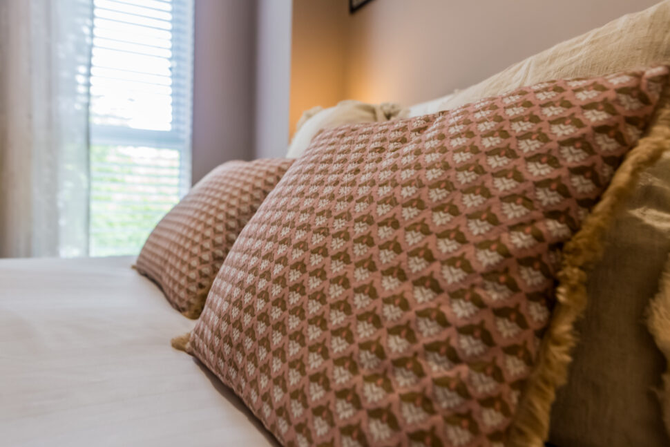Toast Stays, close up of scatter cushions on bed