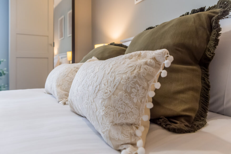 Toast Stays, close up shot of pillows and scatter cushions on bed