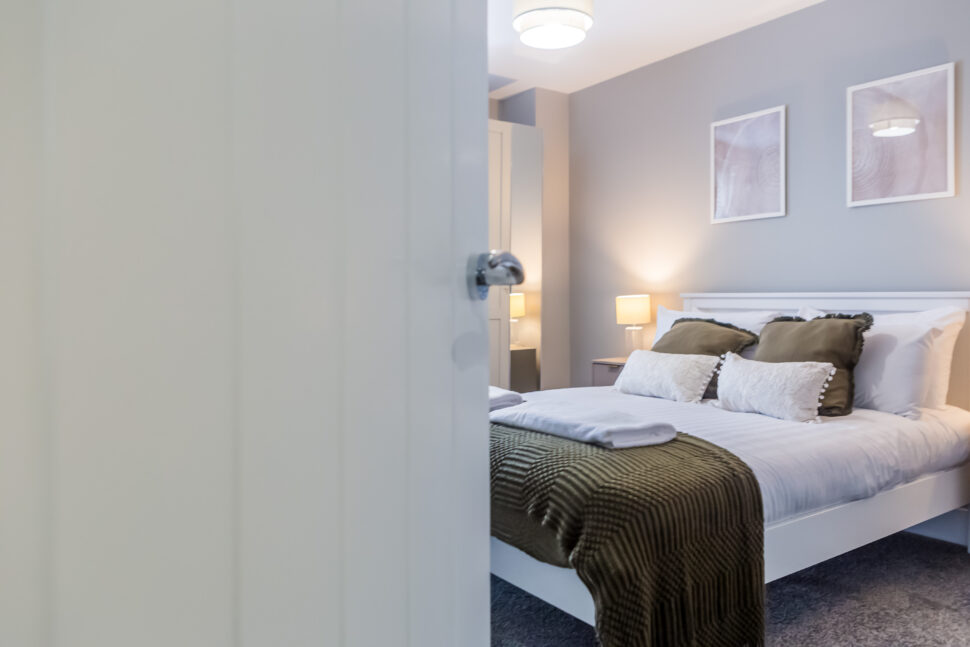 Toast Stays ambient bedroom with coordinated scatter cushions and throw