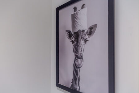 Toast Stays bathroom wall art of giraffe with toilet paper on head