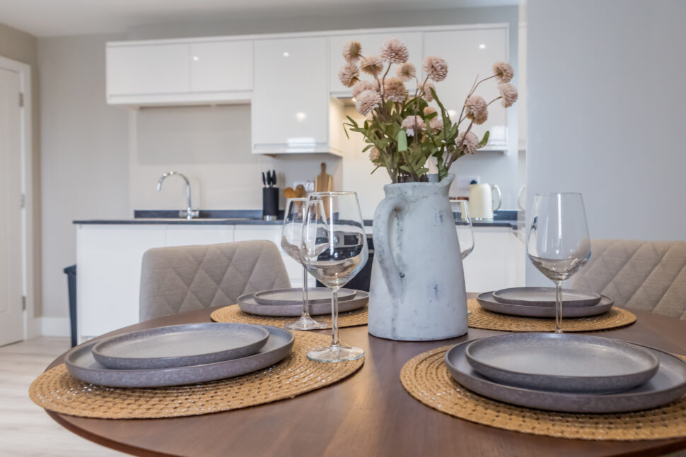 Toast Stays open-plan living, small four seater dining table with place settings and a floral centrepiece