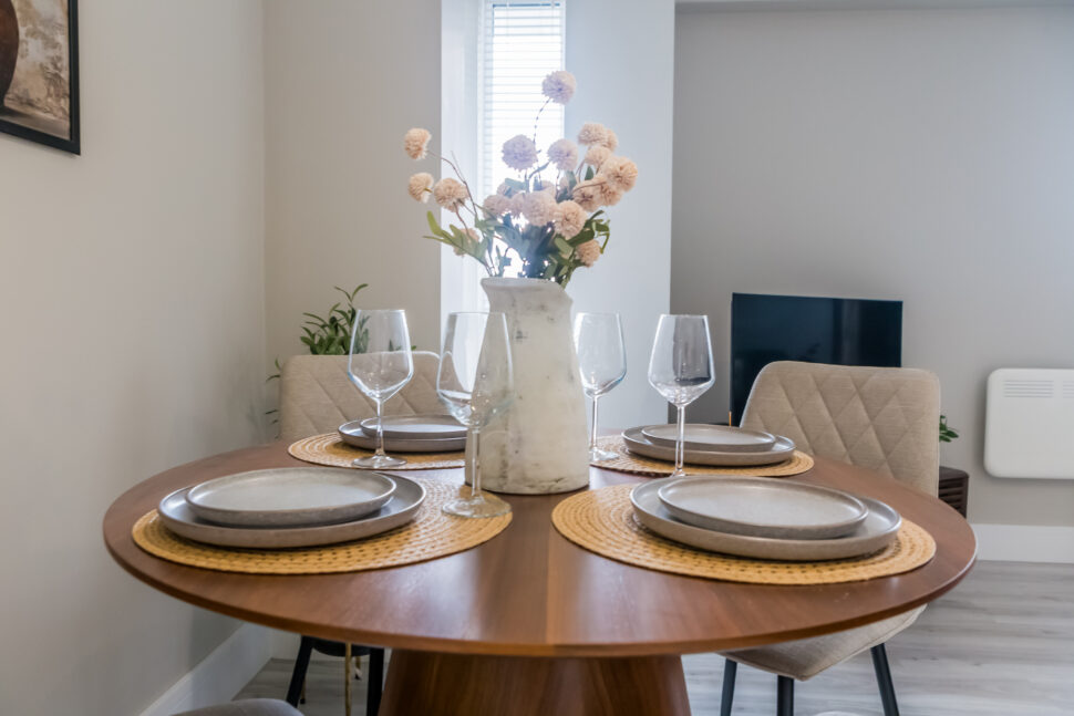 Toast Stays dining area, set with slate coloured plates and floral centrepiece
